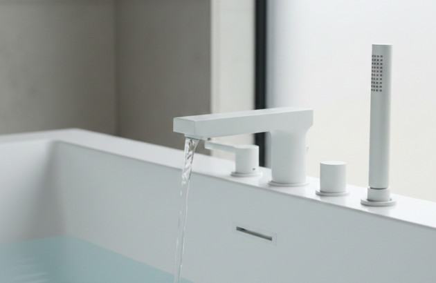 Robinet blanc mat qui fait s'écouler de l'eau dans un lavabo