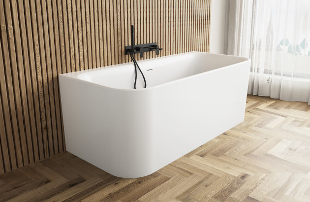 Baignoire blanche adossée à un mur en tasseaux de bois avec robinetterie noire.