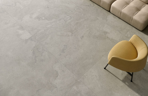 Vue sur du carrelage imitation béton posé au sol d'un vaste salon