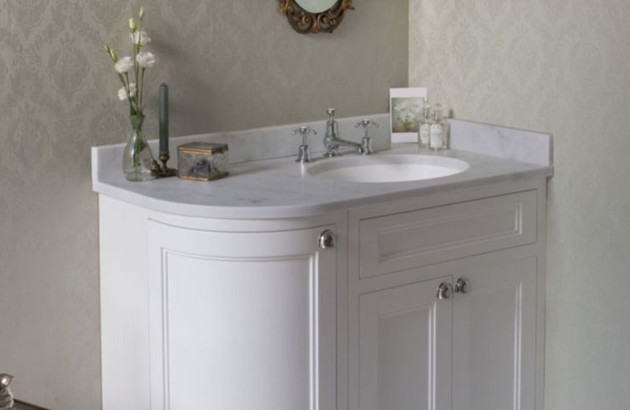 Meuble de salle de bains blanc avec plan vasque arrondi, style classique et élégant.