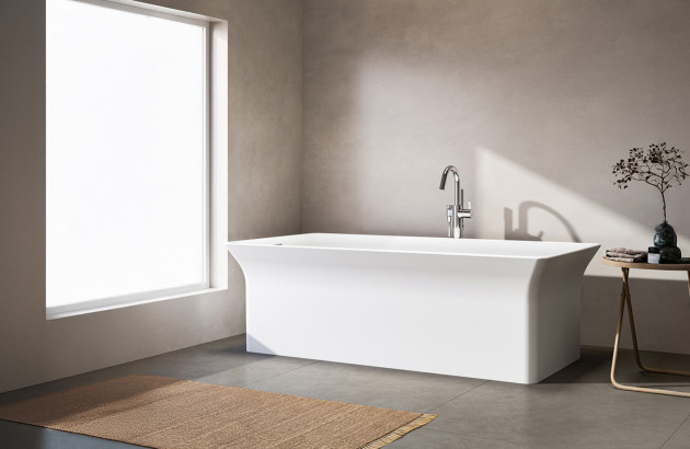 Baignoire îlot blanche aux lignes épurées mise en valeur dans une salle de bains minimaliste et lumineuse.
