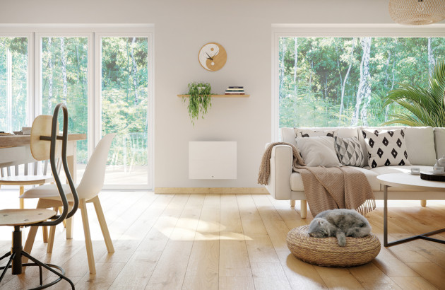 Radiateur positionné entre deux grandes baies vitrées d'un salon de maison