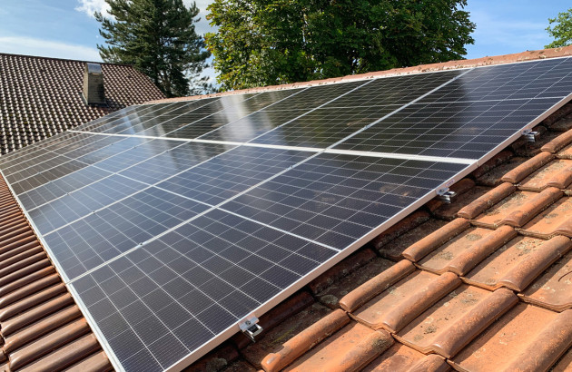 Champ de panneaux solaires photovoltaïques installés sur une toiture de maison