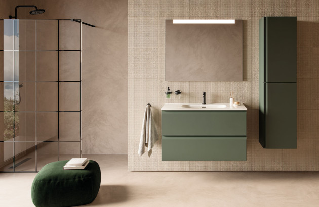 Salle de bains moderne avec meuble vasque vert suspendu, colonne assortie et douche à paroi vitrée noire.
