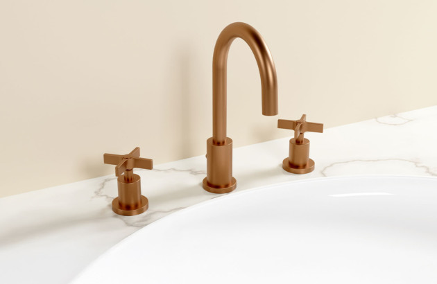 Robinet de lavabo rétro en finition cuivre brossé avec commandes séparées sur un plan de toilette effet marbre.