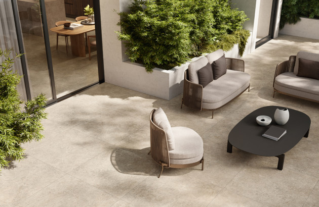 Patio contemporain avec grand carrelage extérieur imitation pierre et salon de jardin design.