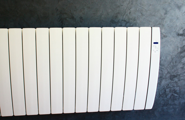 Radiateur électrique blanc installé contre un mur gris