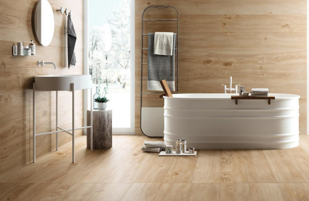 Salle de bains avec carrelage imitation bois et baignoire îlot pour une atmosphère zen.