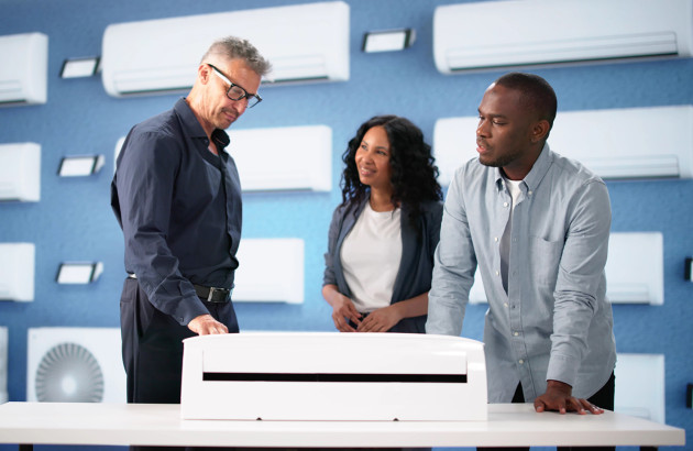 Conseiller présentant une climatisation réversible en showroom, accompagnement pour achat et choix du modèle