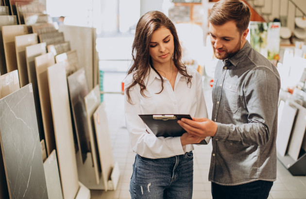 Couple étudiant différents échantillons de carrelage dans un magasin spécialisé.