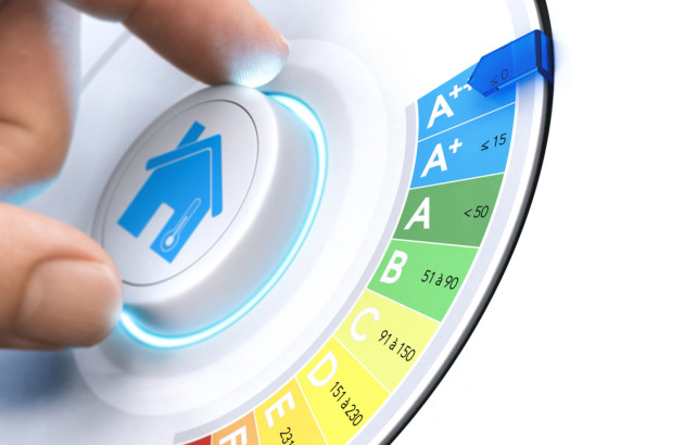 Main appuyant sur un bouton “maison” avec étiquette énergie A+++ à côté, illustration d’un logement performant.