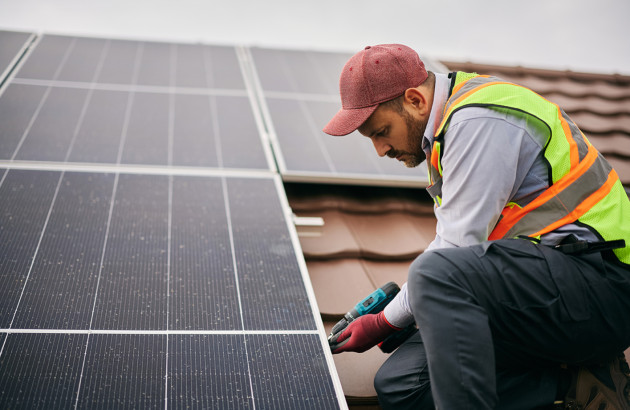 Technicien installant un panneau solaire sur un toit