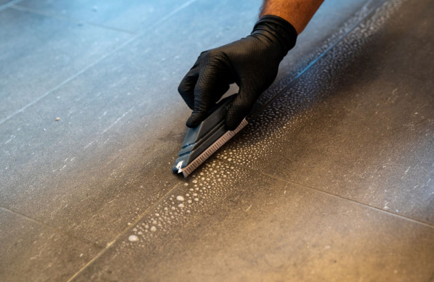 Homme qui nettoie les joints de carrelage