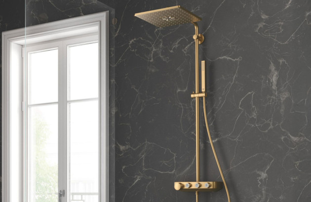 Colonne de douche dorée sur fond marbre noir, pour une salle de bains élégante et raffinée.
