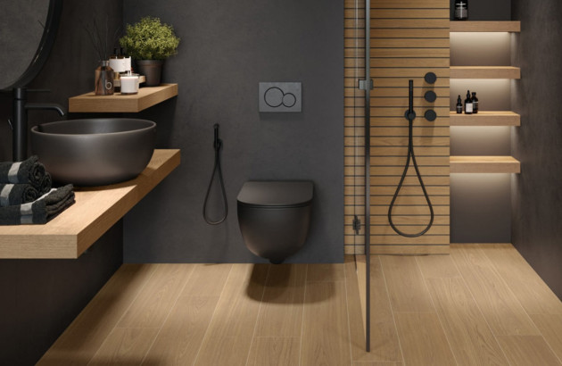 WC suspendu noir dans une salle de bains moderne associant bois clair et murs foncés.