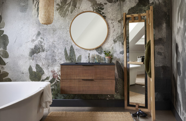 Meuble de salle de bains en bois foncé dans une salle de bains avec un mur floral