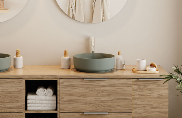 Meuble de salle de bains en bois clair avec vasque ronde vert doux dans un esprit scandinave et apaisant.