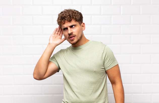 Homme qui tend l'oreille pour écouter le bruit du carrelage