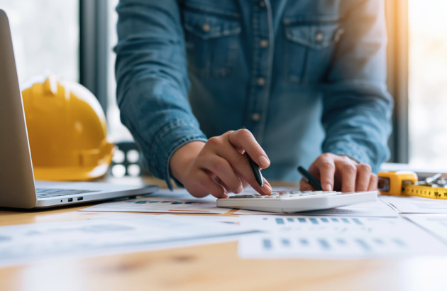 Professionnel calculant les besoins et la puissance nécessaire pour dimensionner une installation de chauffage.