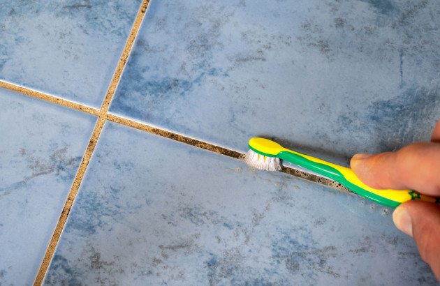 Nettoyage des joints de carrelage avec une brosse à dent