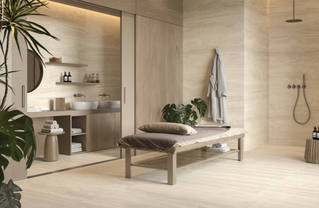 Salle de bains beige esprit spa avec double vasque, douche à l’italienne et banc en bois.