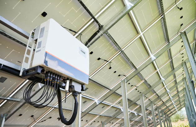 Onduleur solaire installé sous une installation de panneaux solaires