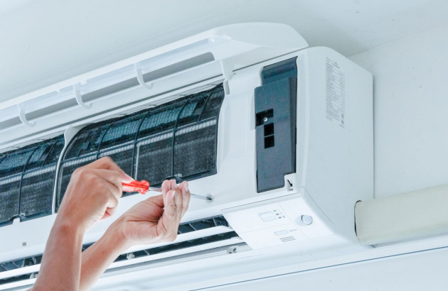Personne qui visse une climatisation