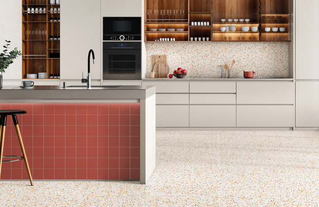 Cuisine ouverte avec deux types de faience murale, petits carreaux rouges et grands carreaux effet terrazzo