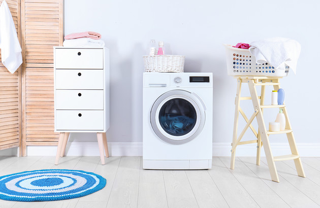 Machine à laver bien aménagée dans une salle de bains