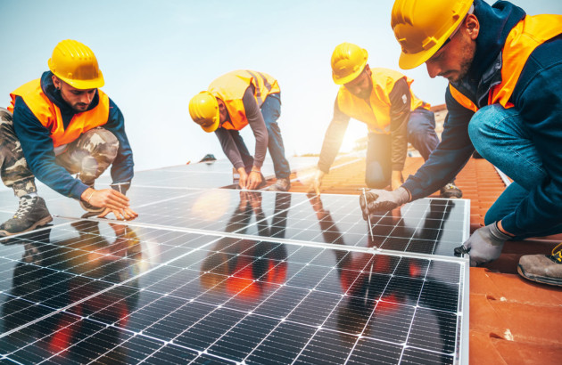 4 ouvriers en train de poser des panneaux solaires