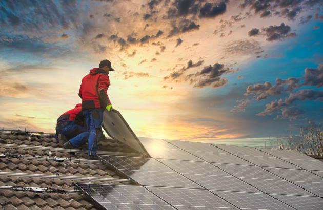 2 ouvriers Quali'EnR qui installent un panneau photovoltaïque sur un toit