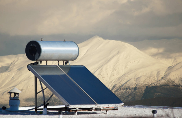 Panneau solaire thermique sur le toit d'une maison avec des montagnes à l'arrière plan