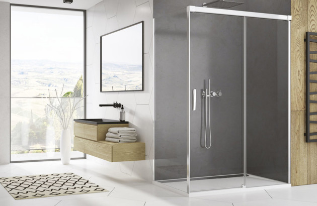 Cabine de douche d’angle avec parois vitrées coulissantes et profilés métalliques.