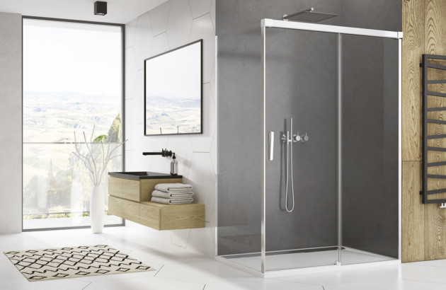 Cabine de douche rectangulaire avec portes vitrées coulissantes et profilés chromés dans une salle de bains moderne.