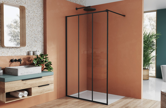 Paroi de douche noire dans une salle de bains au mur orange
