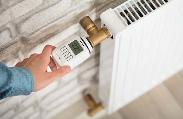 personne réglant son robinet thermostatique