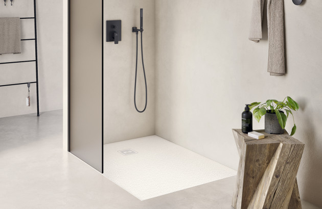 Douche à l’italienne minimaliste avec receveur blanc encastré et robinetterie noire.