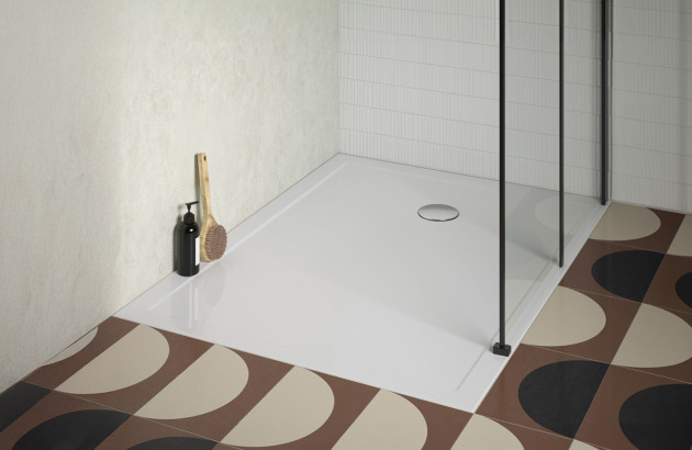 Receveur de douche blanc extra-plat avec bonde centrale et paroi vitrée noire.