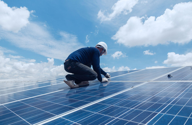 Professionnel intervenant sur une installation de panneaux solaires photovoltaïques.