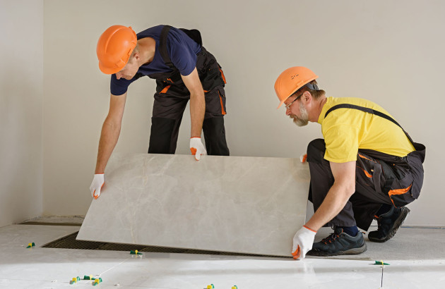 Professionnels qui posent du carrelage grand format