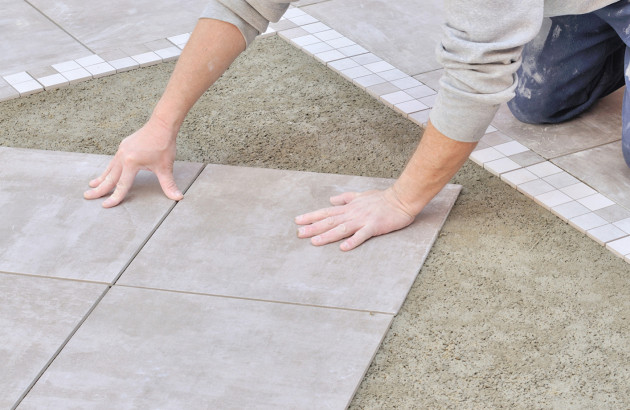Personne qui réalise une pose de carrelage