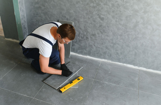 carreleur en train de poser du carrelage effet béton