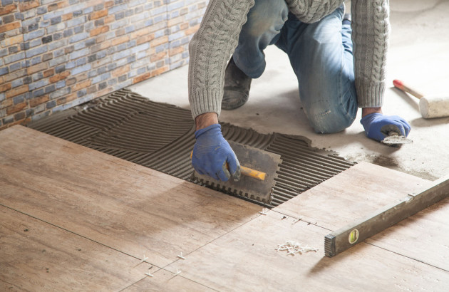 Professionnel qui pose du carrelage