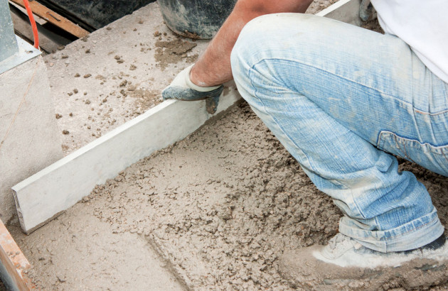 Homme qui pose une chape maigre en béton