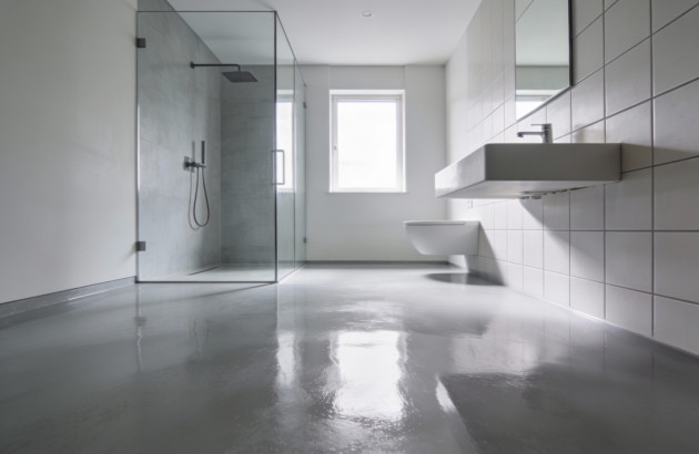 Salle de bains avec sol en béton et carrelage blanc mural