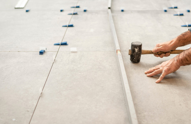 Professionnel qui réalise une pose de carrelage très soignée