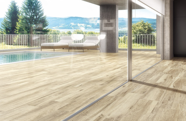 Terrasse contemporaine avec carrelage imitation bois clair et vue panoramique sur un paysage naturel.