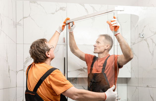 deux professionnels posant une paroi de douche