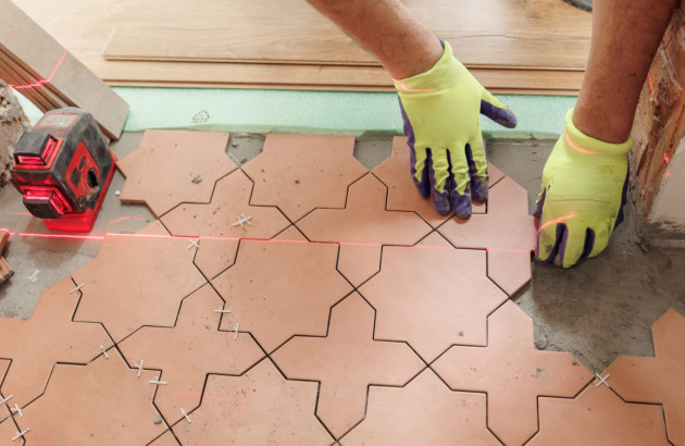 Personne qui pose du carrelage terracotta