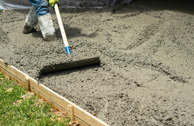 Ouvrier qui étale le béton pour réaliser la dalle